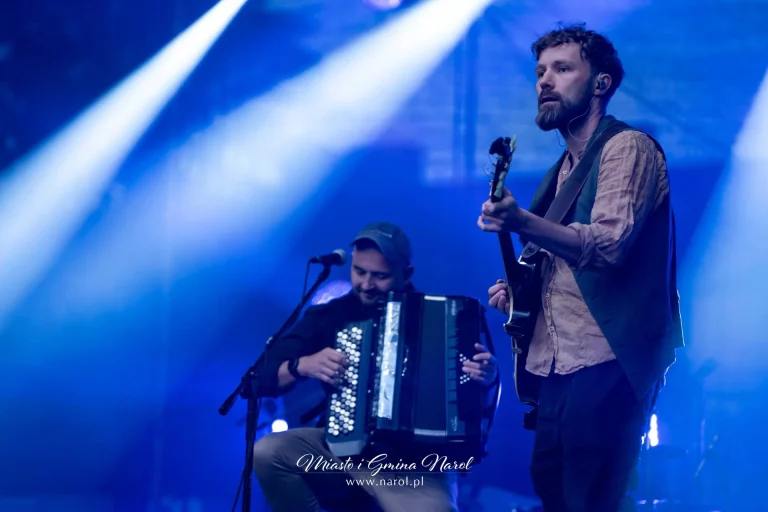 Wokalista Propabanda z gitarą śpiewający na scenie w niebieskim świetle