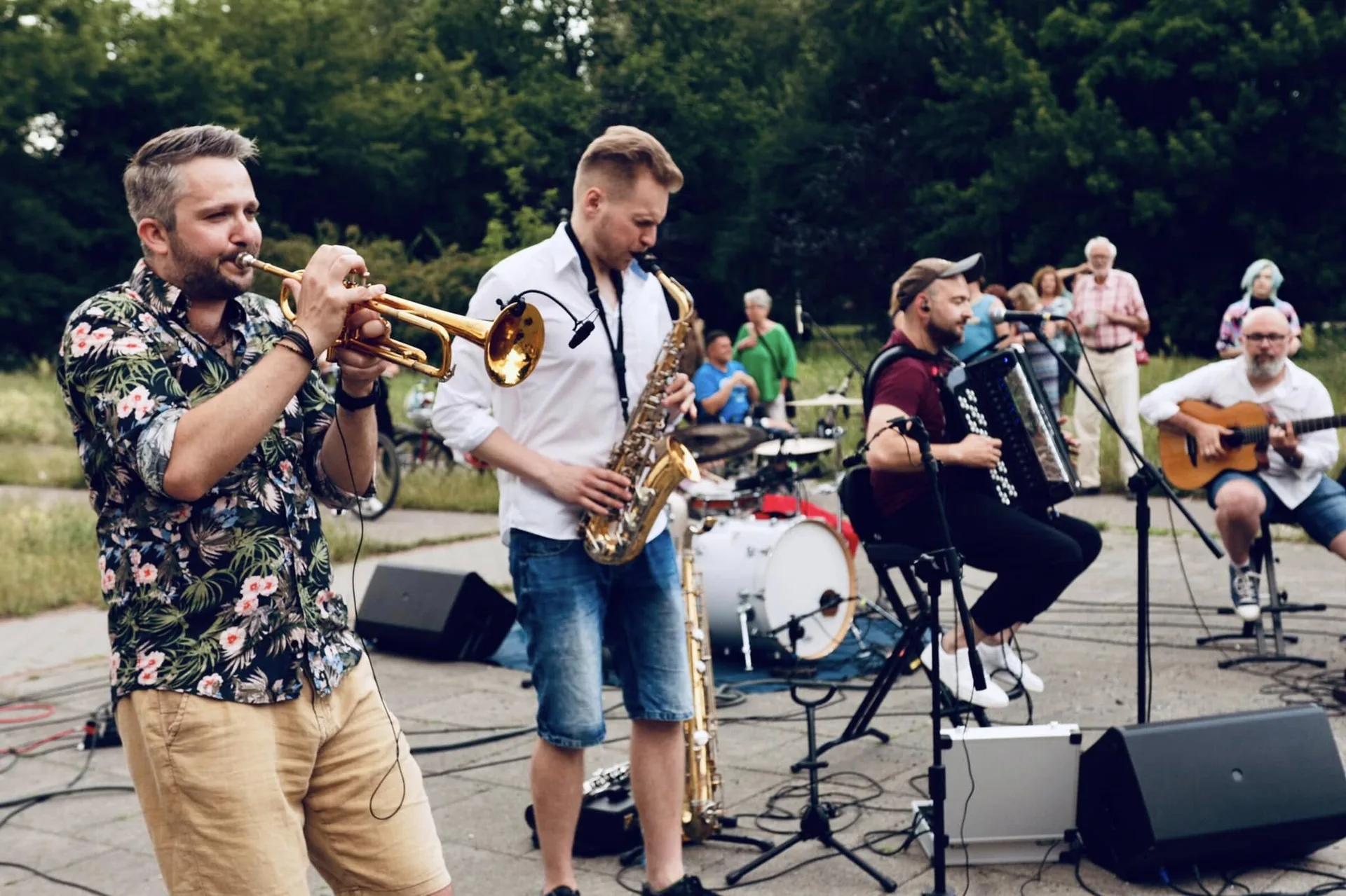 Zespół Propabanda na plenerowej scenie z trąbką, saksofonem, perkusją i gitarą, w tle bloki