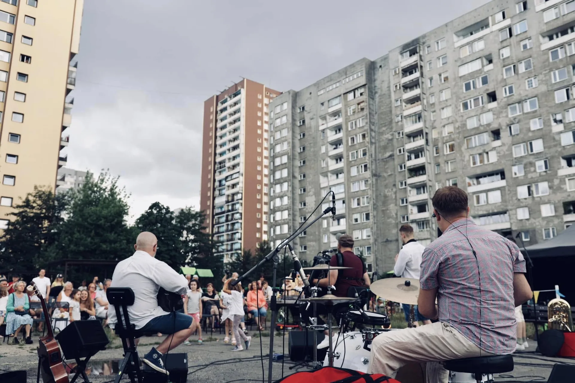Zespół Propabanda grający na plenerowej scenie przed publicznością siedzącą na osiedlu