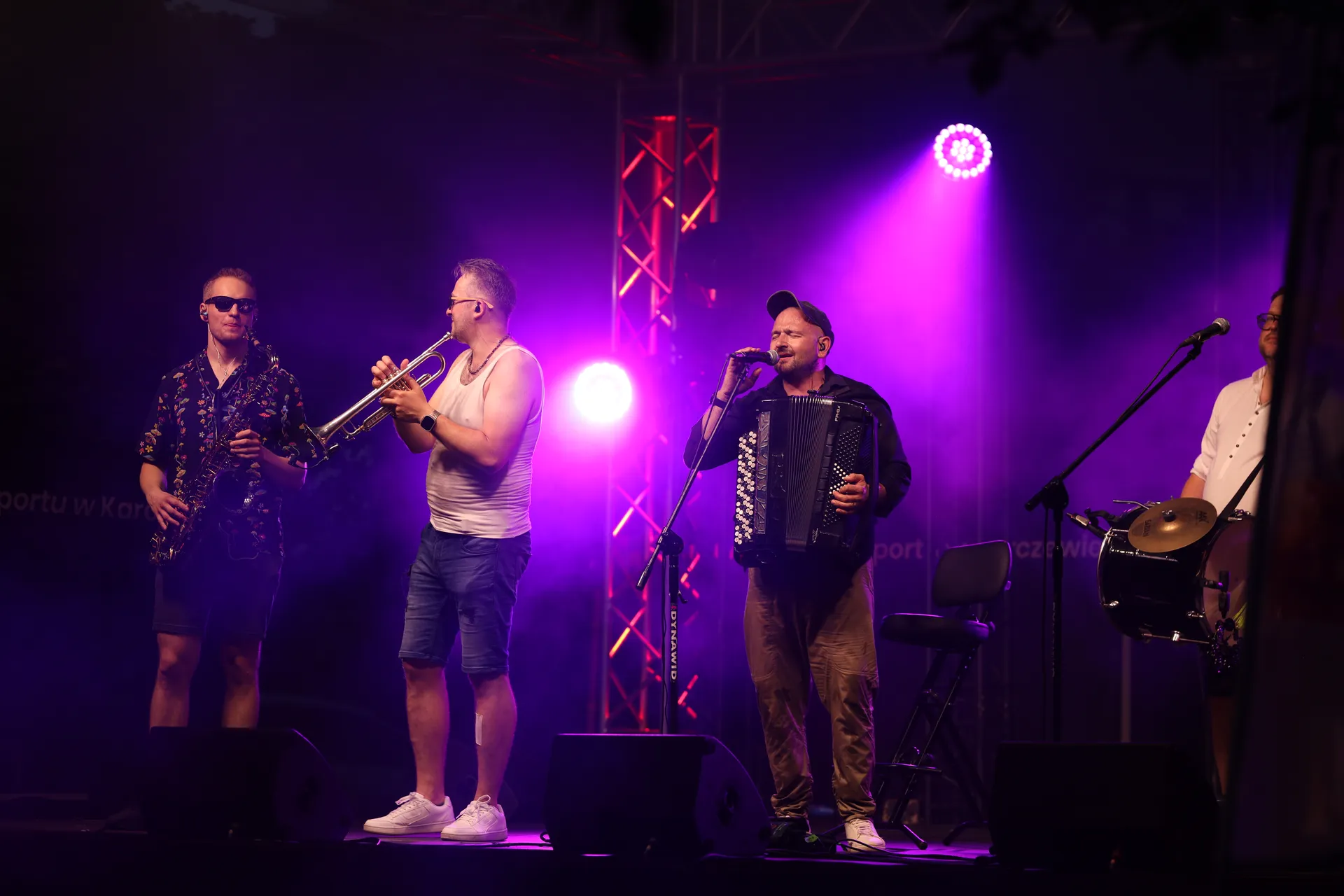 Sekcja dęta i wokalista Propabanda na scenie w fioletowym świetle